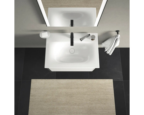 Ansicht von oben eines Badezimmers mit Waschbecken, Spiegel, Handtuch und Badteppich