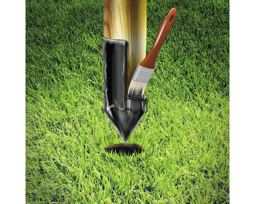 Pfosten mit Teeranstrich und Pinsel auf Rasen