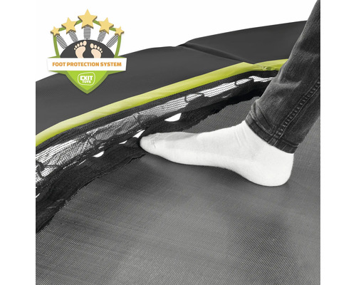 Detailansicht eines Trampolins mit Fußschutzsystem und einem Fuß in weißer Socke auf dem Sprungtuch.