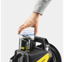 Ein Mann setzt einen Kanister mit Autoshampoo auf einen Hochdruckreiniger