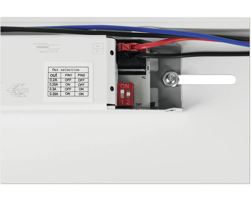 Detailansicht eines elektronischen Geräts mit Kabeln, Schaltern und Ausgangsauswahltabelle.