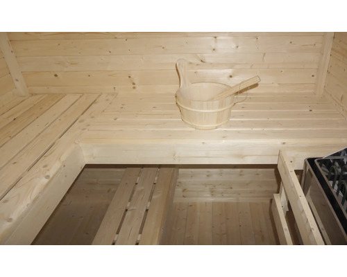 Innenraum einer Sauna mit Holzeimer und Holzlöffel