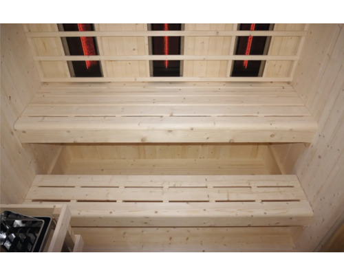 Innenansicht einer Sauna mit Holzsitzen und Infrarotstrahlern an der Decke