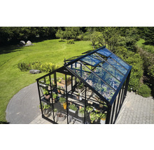 Gewächshaus mit Pflanzen und geöffneten Fenstern im Garten
