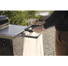 Person befestigt Müllbeutel an Grillwagen für eine saubere und praktische Grillumgebung.