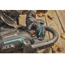 Eine Person leert mit Gartenhandschuhen einen Gardena Akku-Laubsauger