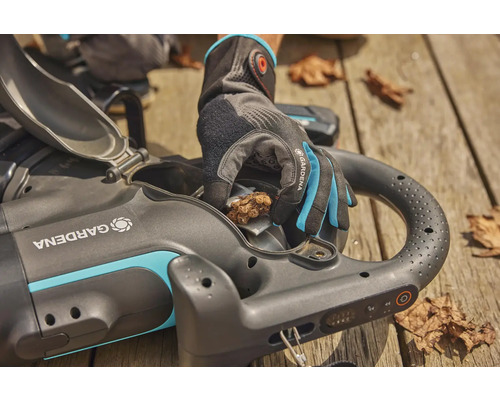 Eine Person leert mit Gartenhandschuhen einen Gardena Akku-Laubsauger