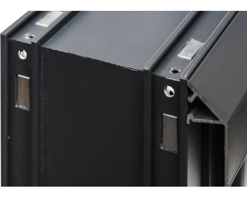 Detailansicht eines schwarzen Aluminiumprofils mit Magneten und Schraubenlöchern