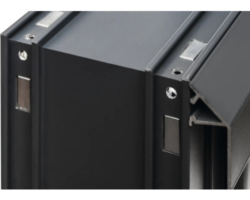 Detailansicht eines schwarzen Aluminiumprofils mit Magneten und Schraubenlöchern.