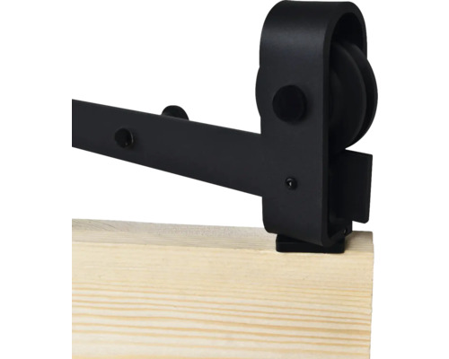 Detailansicht einer schwarzen Schiebetürbeschlag auf einem Holzbrett.