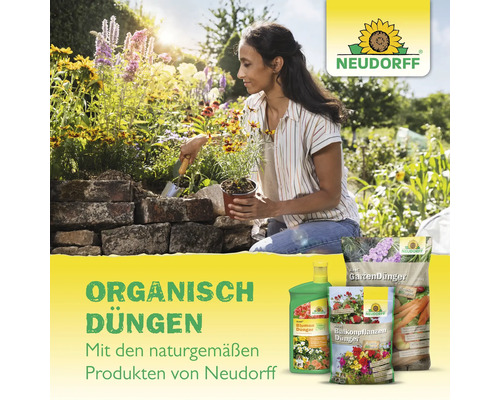 Frau pflanzt Blumen mit Neudorff Gartendünger im Garten.