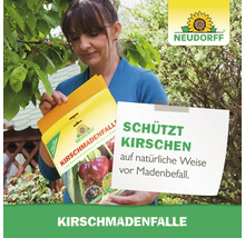 Frau hält Neudorff Kirschmadenfalle zum Schutz von Kirschen vor Madenbefall
