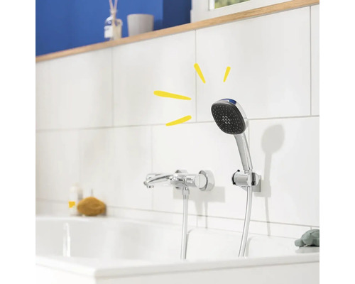 Aufnahme einer Handbrause mit Duschschlauch und Armatur an einer weißen Wand in einem Badezimmer.