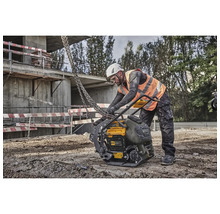 Bauarbeiter bedient eine gelbe DeWalt Rüttelplatte auf einer Baustelle