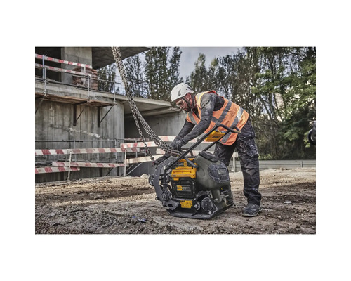 Bauarbeiter bedient eine gelbe DeWalt Rüttelplatte auf einer Baustelle