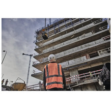 Bauarbeiter beobachtet Rüttelplatte an Baustelle