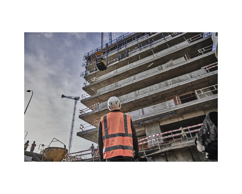 Bauarbeiter beobachtet Rüttelplatte an Baustelle