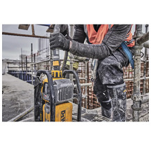 Ein Bauarbeiter bedient einen tragbaren Betonrüttler der Marke DeWalt auf einer Baustelle.