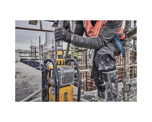 Ein Bauarbeiter bedient einen tragbaren Betonrüttler der Marke DeWalt auf einer Baustelle.