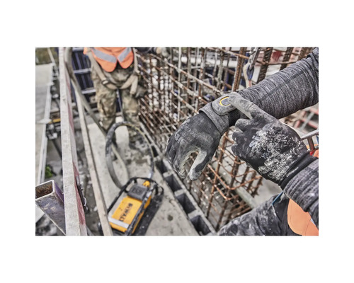 Eine Person trägt DeWalt-Arbeitshandschuhe auf einer Baustelle