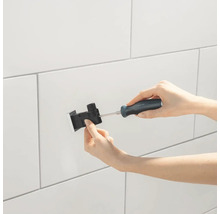 Installation einer Armatur mit Schraubendreher an einer Wand.