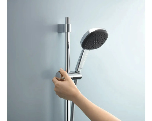 Handbrause mit Brausestange und Hand in Chromoptik im Badezimmer