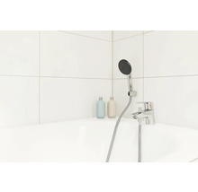 Badezimmer mit Armatur, Brausekopf und zwei Flaschen auf dem Badewannenrand