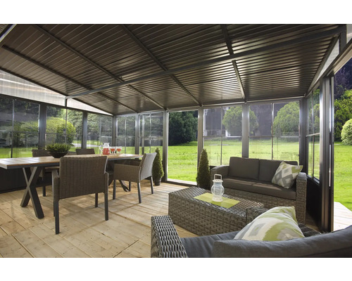Verglaster Pavillon mit Sitzgruppe und Esstisch im Garten