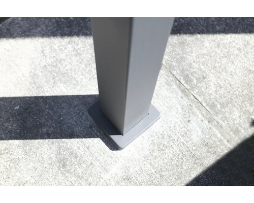 Detailansicht einer grauen Terrassenüberdachung Pfostenbefestigung auf Betonboden.