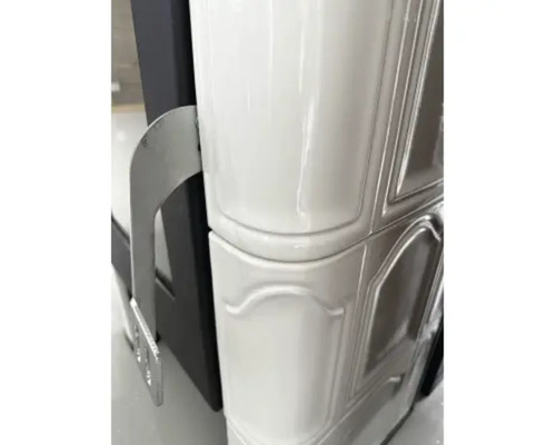 Detailansicht eines Kaminofens mit Keramikverkleidung und silberfarbenem Griff