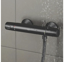Schwarzer Grohe Duschthermostat mit Brauseschlauch an gefliester Wand