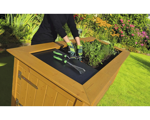 Hochbeet mit Kräutern, Gartengeräten und einer Person in einem Garten