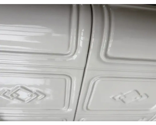 Detailaufnahme einer weißen Paneeldecke mit geprägtem Muster