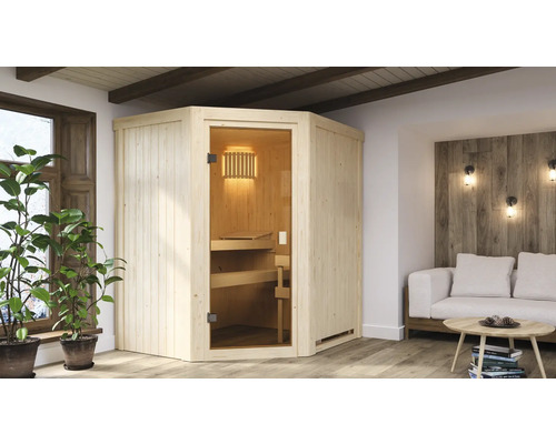 Saunahaus Karibu Avanti inkl. 3,6 kW Ofen ikl.integr.Steuerung ohne Dachkranz mit bronzierte Ganzglastür Ecksauna aus Holz mit Glastür in einem hellen Wohnraum