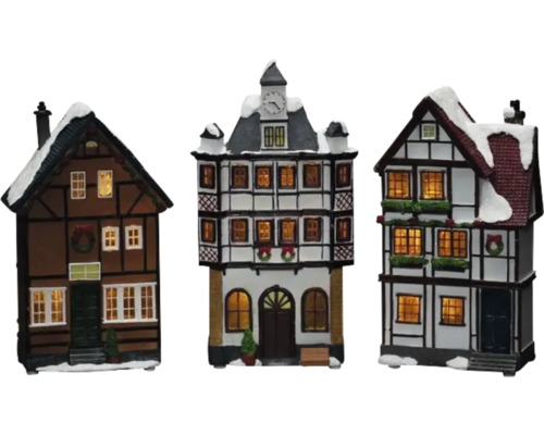 Drei dekorative Fachwerkhäuser mit Beleuchtung und Schnee für die Weihnachtszeit