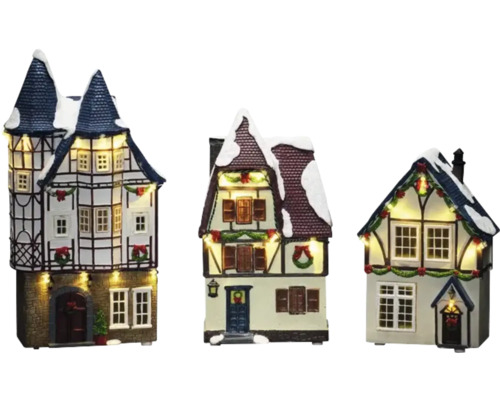 Drei beleuchtete Weihnachtshäuser aus Kunstharz mit Schnee auf den Dächern und festlicher Dekoration
