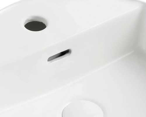 Detailansicht eines weißen Waschtisches mit Hahnloch und Überlauf