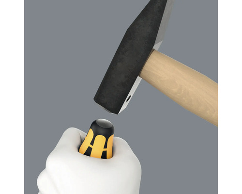 Hammer schlägt auf einen Schraubendreher-Griff in einer Hand