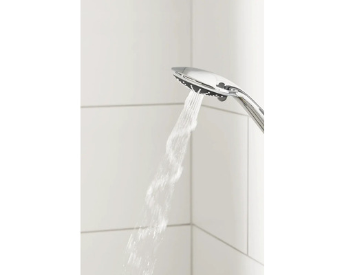Duschkopf mit Wasserstrahl vor weißem Fliesenhintergrund
