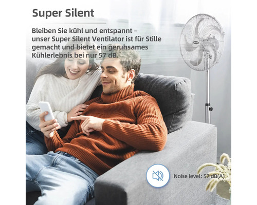 Ein Paar entspannt sich auf dem Sofa, während ein Standventilator für Kühlung sorgt.