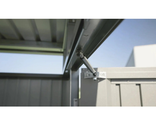 Detailansicht Gasdruckfeder an einem Gerätehaus.