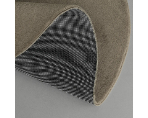 Detailansicht eines runden Teppichs mit Teppichrücken