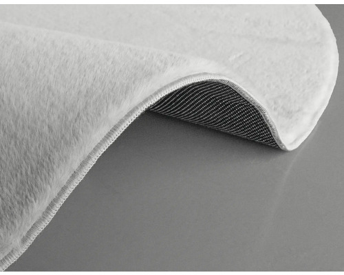 Detailansicht eines weißen Teppichs mit Flor und Textilrücken