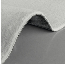 Detailansicht eines hellen Teppichs mit Flor und gewebter Rückseite