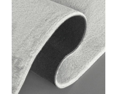 Detailansicht eines hellen Teppichs mit weicher Oberfläche und rutschfester Unterseite