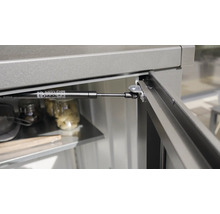 Detailansicht einer Gasdruckfeder an einem Gartenschrank