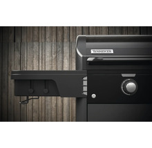 Detailansicht eines schwarzen Gasgrills mit Seitenablage und Tenneker Logo.