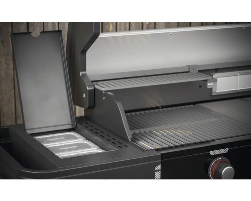 Detailansicht eines schwarzen Gasgrills mit Warmhalterost und Behältern