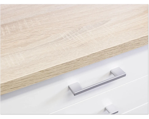 Detailaufnahme einer Kommode mit hellbrauner Holzplatte und silberfarbenen Griffen