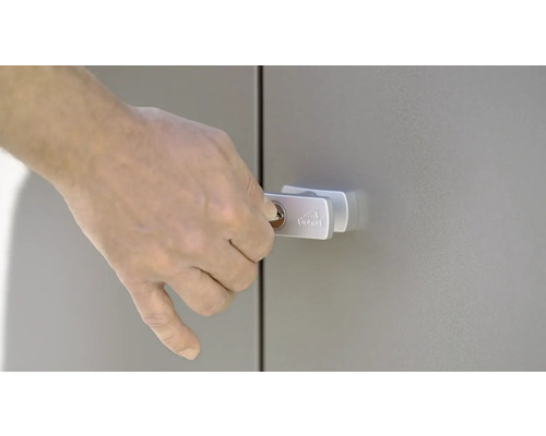 Eine Hand schließt einen Metallschrank mit einem Schlüssel ab